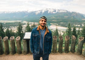 Man stands smiling with mountains in the background, Revelstoke, Canada.